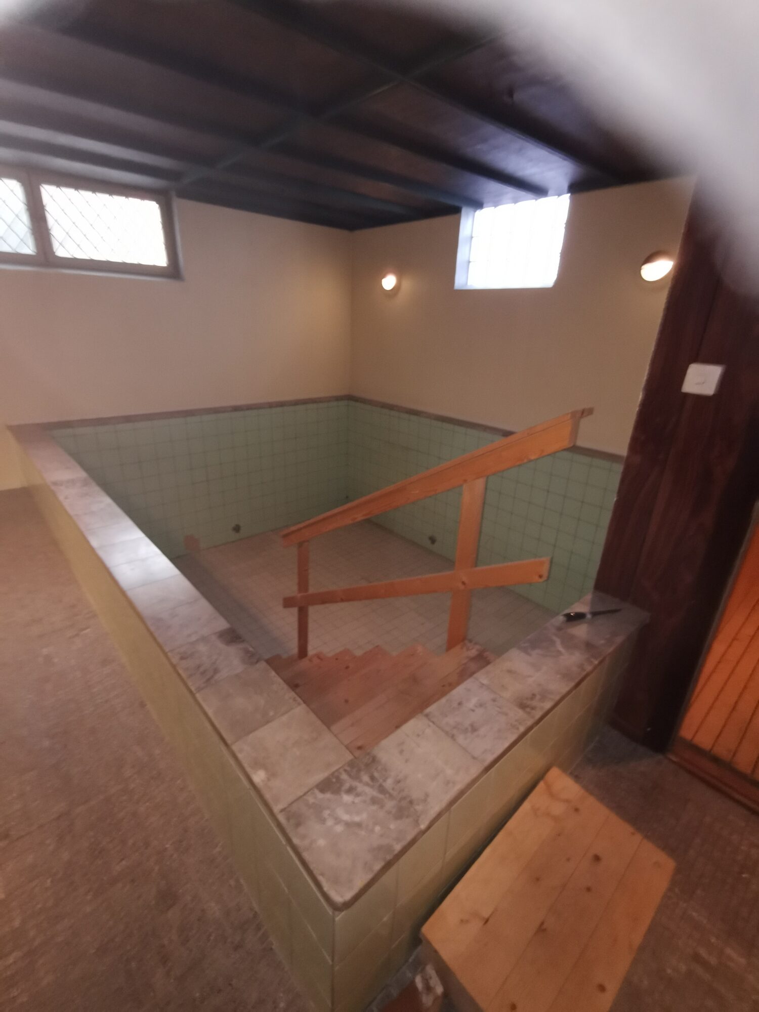 Gammal kaklad inomhuspool i källare före renovering